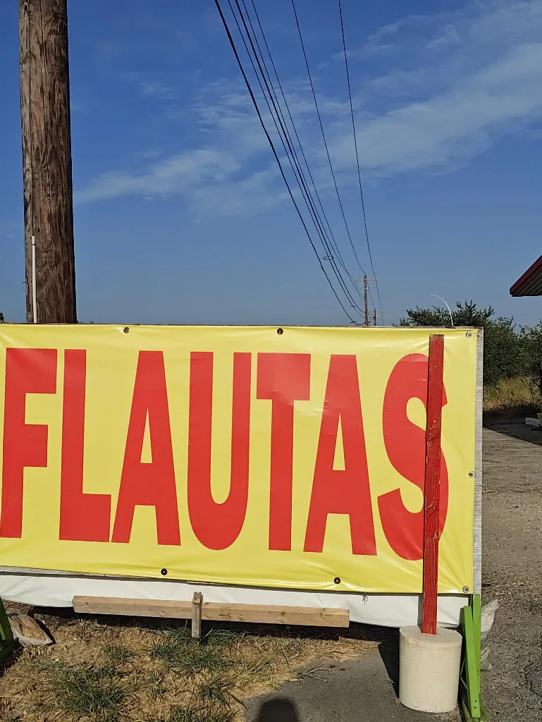 Lona amarilla con la palabra FLAUTAS en letras rojas grandes.